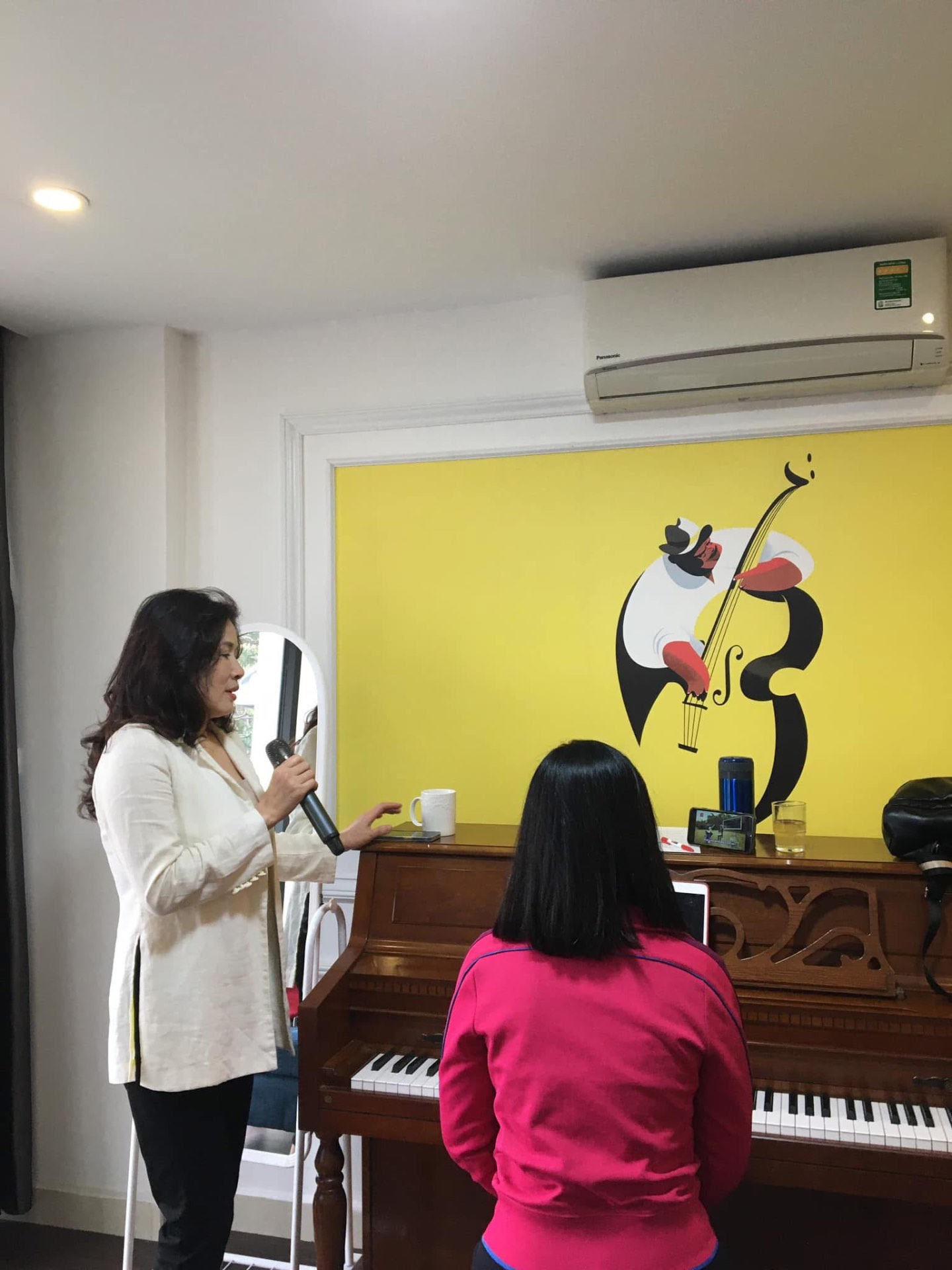 Giáo viên quan sát và hướng dẫn trực tiếp học viên trong buổi học tại Piano Đệm Hát