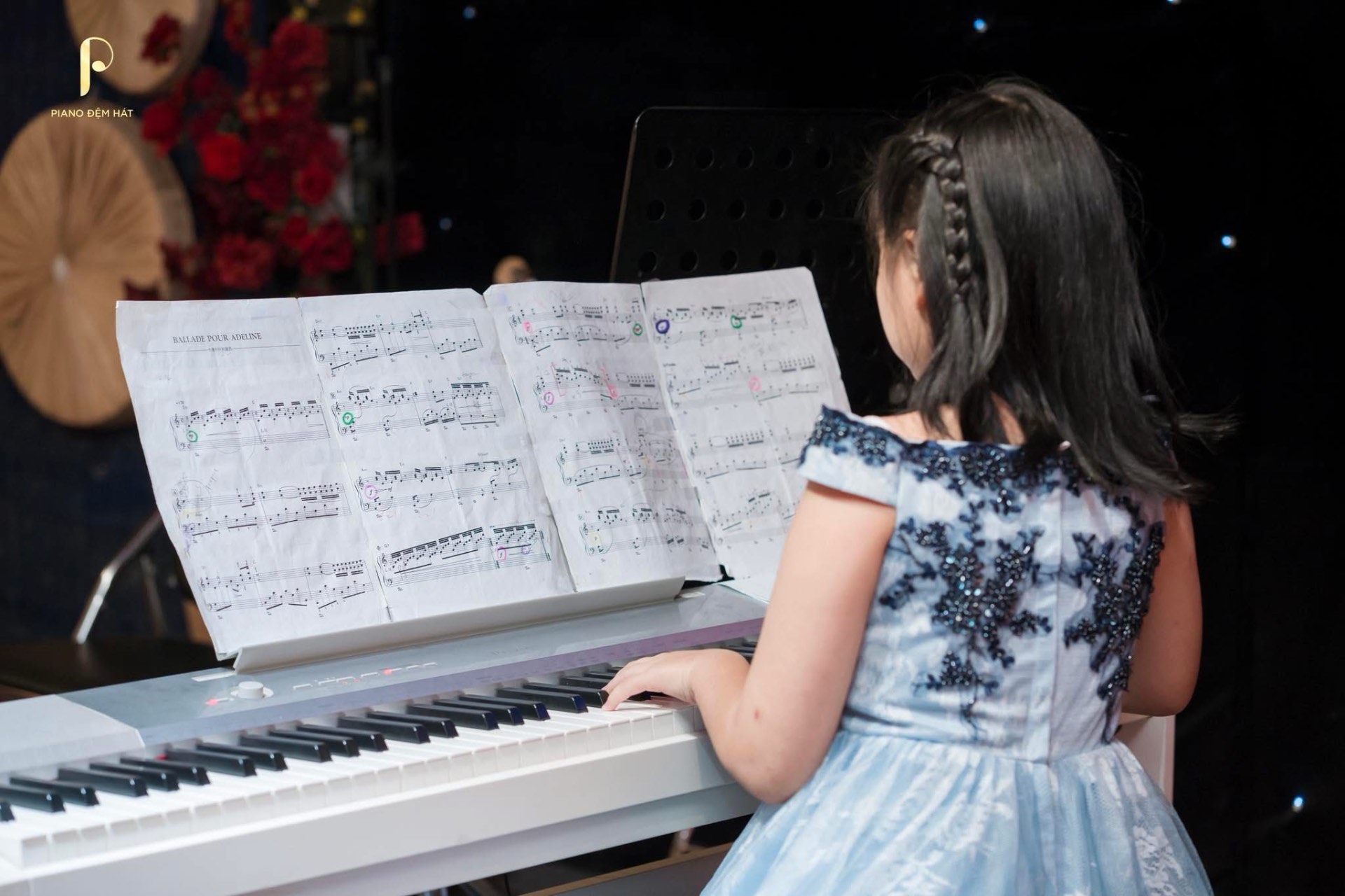 Học viên nhỏ tuổi biểu diễn piano trên sân khấu